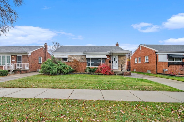 bungalow-style house featuring brick siding and a front yard