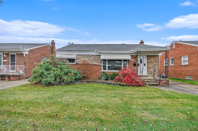 view of front of house featuring a front yard, stone siding, brick siding, and a chimney