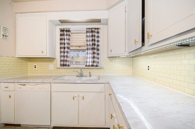 kitchen featuring tasteful backsplash, dishwasher, sink, and white cabinets