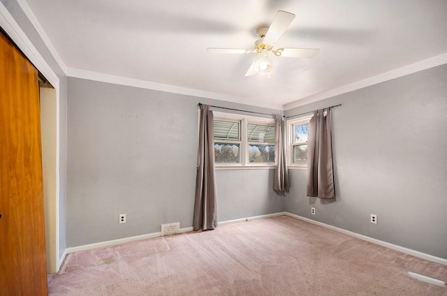 empty room with crown molding and light carpet