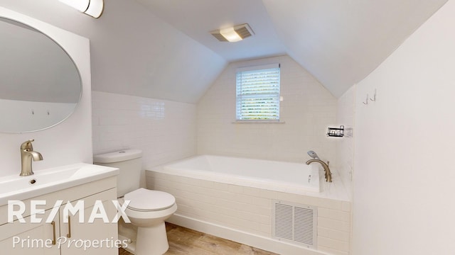 bathroom with vanity, lofted ceiling, hardwood / wood-style flooring, toilet, and tiled tub