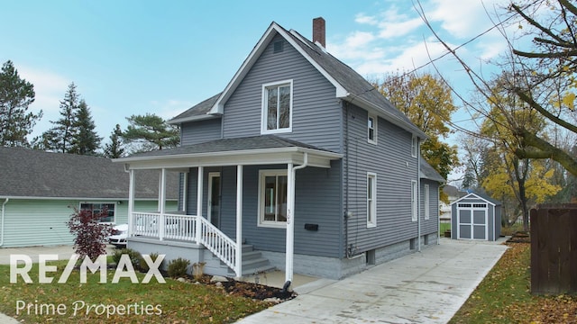 view of front of home with covered porch and a shed