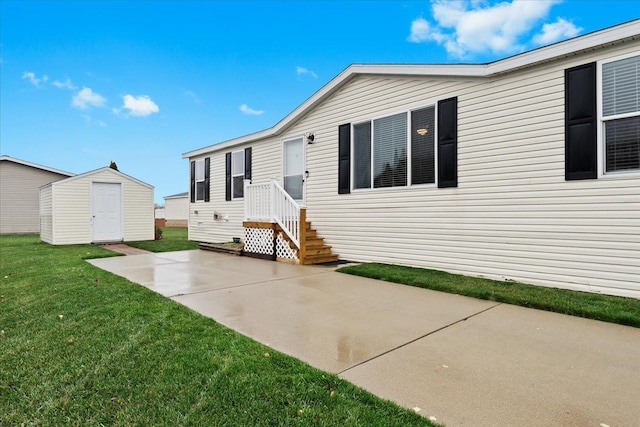 rear view of house featuring a yard and a storage shed