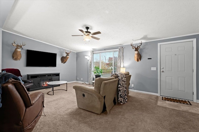 carpeted living room featuring ceiling fan, a textured ceiling, and ornamental molding