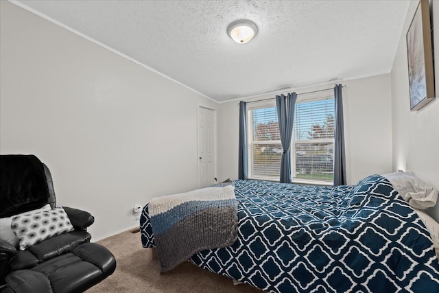 bedroom featuring carpet flooring, ornamental molding, and a textured ceiling