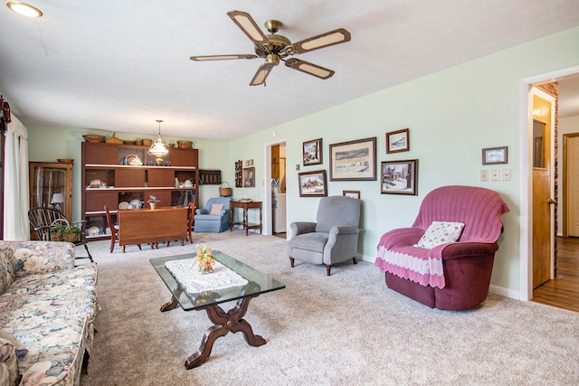 carpeted living room with ceiling fan