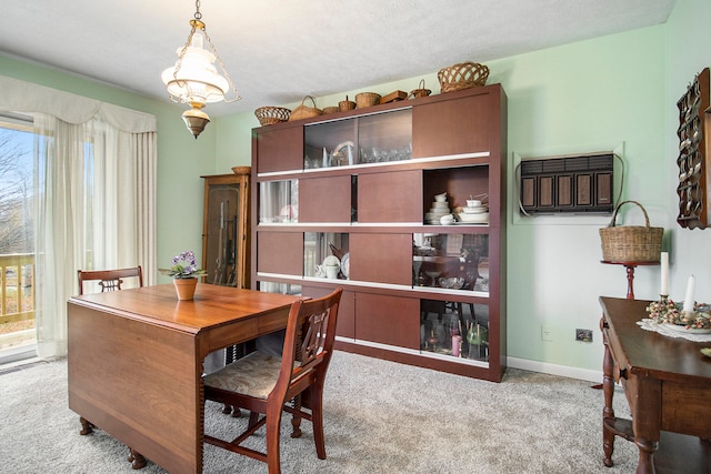 carpeted dining room featuring a textured ceiling