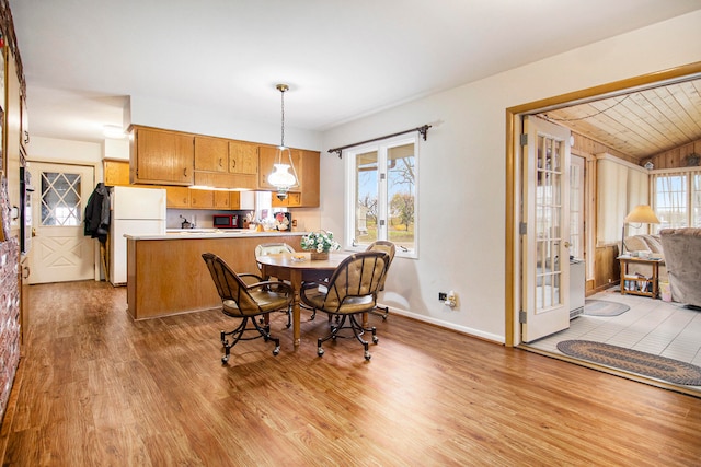 dining room with wood ceiling and light wood-type flooring