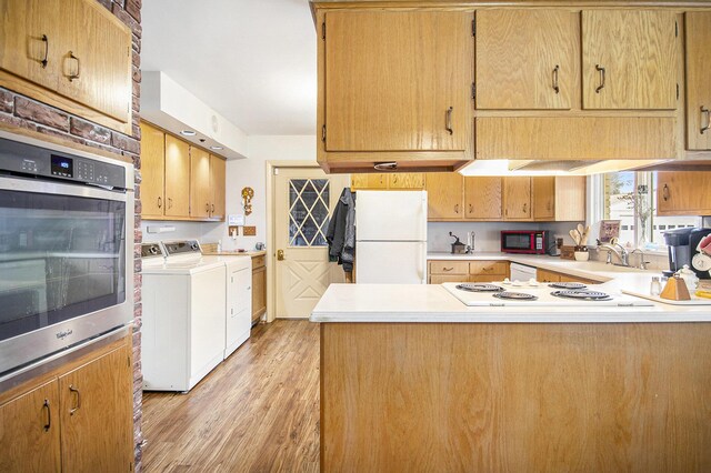7349 E Main St, Eau Claire, MI 49111 - kitchen featuring white appliances, washer and dryer, a sink, a peninsula, and light countertops