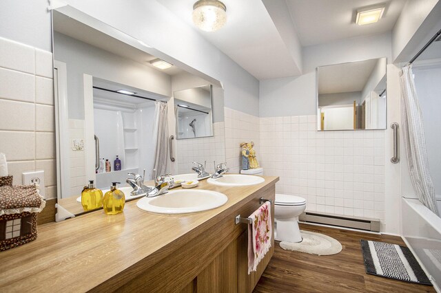 7349 E Main St, Eau Claire, MI 49111 - full bathroom with baseboard heating, tile walls, double vanity, toilet, and shower / bath combo with shower curtain
