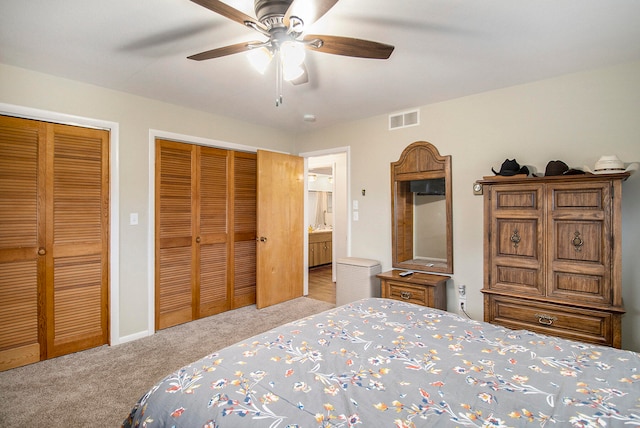 bedroom featuring light carpet, connected bathroom, ceiling fan, and multiple closets