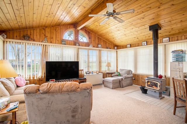 living room featuring wood ceiling, light colored carpet, lofted ceiling with beams, a wood stove, and wood walls