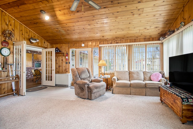 carpeted living room with vaulted ceiling, a wealth of natural light, wooden walls, and wood ceiling