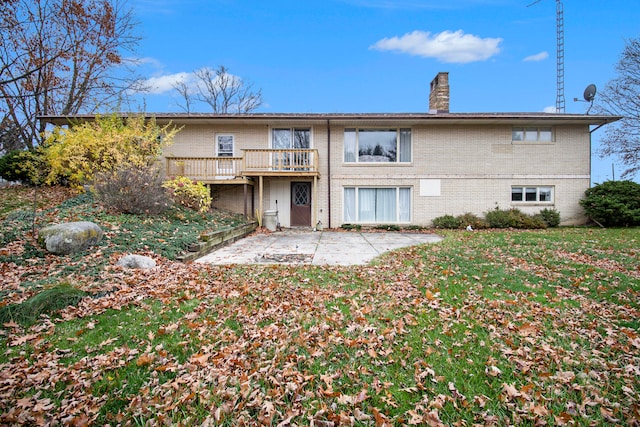 back of house with a wooden deck and a patio