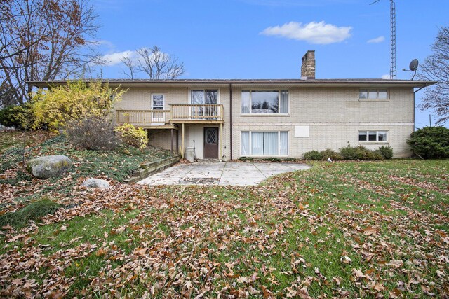 7349 E Main St, Eau Claire, MI 49111 - back of property with a patio, a chimney, brick siding, a lawn, and a deck