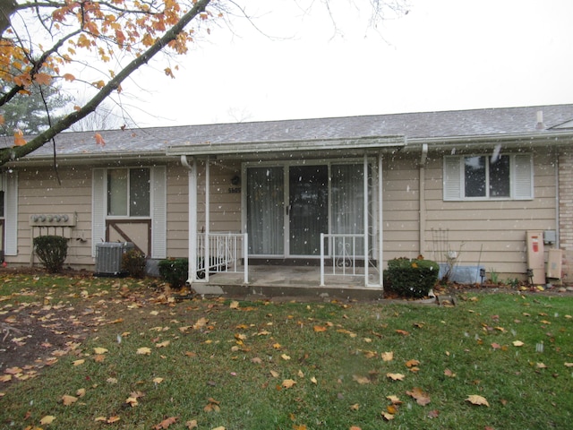 exterior space with a front lawn and central AC unit