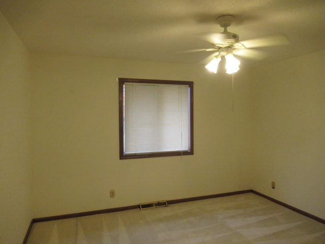 carpeted spare room with ceiling fan