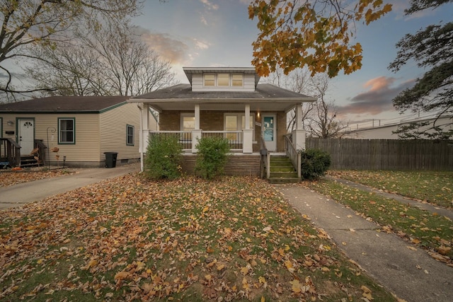 bungalow-style house with covered porch and a yard