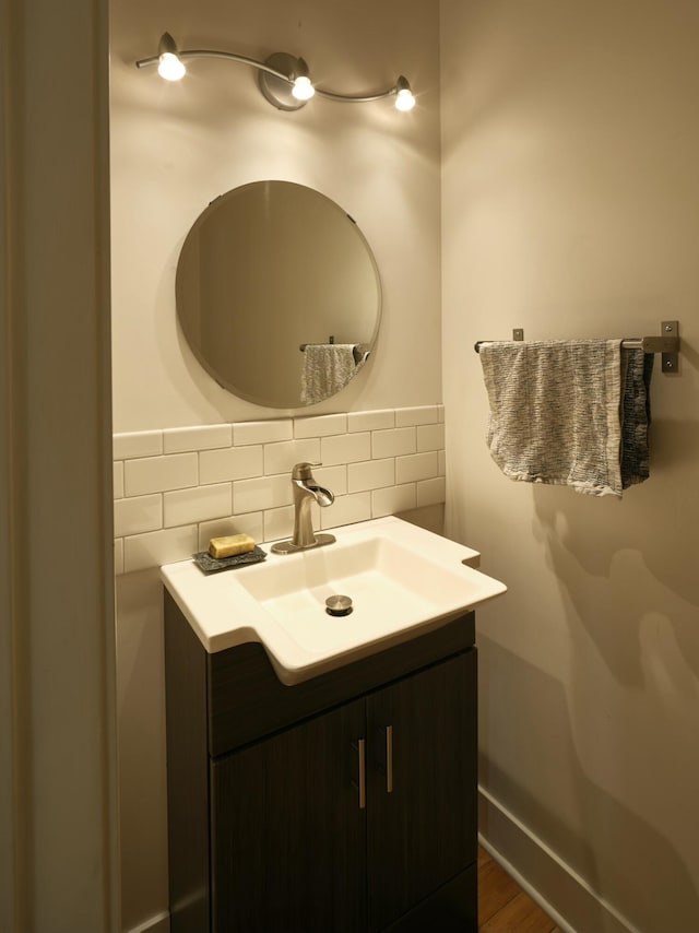 bathroom featuring decorative backsplash, hardwood / wood-style floors, and vanity