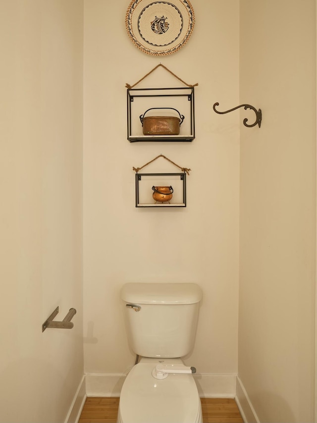 bathroom with hardwood / wood-style flooring and toilet