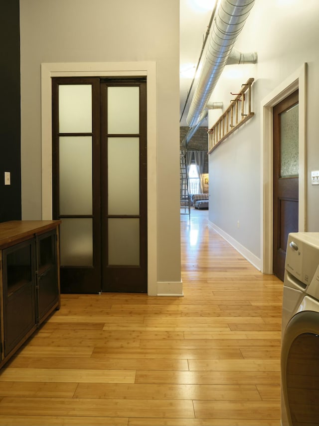 hall featuring washer / dryer and light wood-type flooring