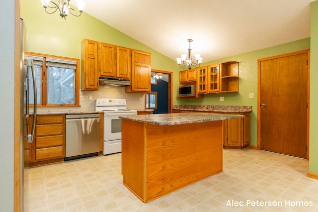 kitchen with appliances with stainless steel finishes, a kitchen island, hanging light fixtures, and a notable chandelier