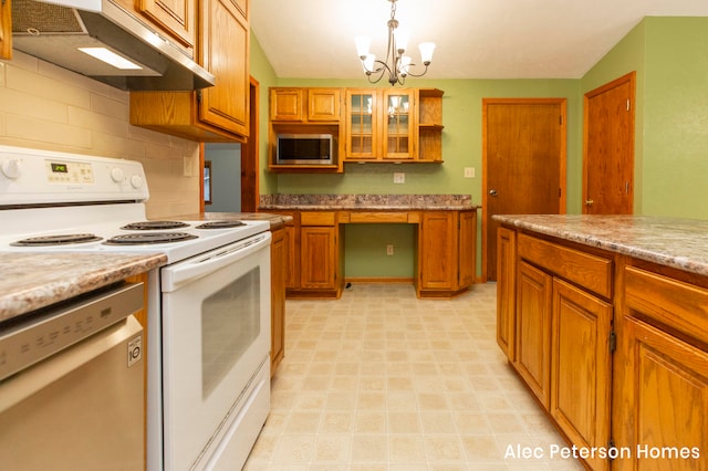 kitchen with hanging light fixtures, electric range, stainless steel dishwasher, light stone counters, and a chandelier