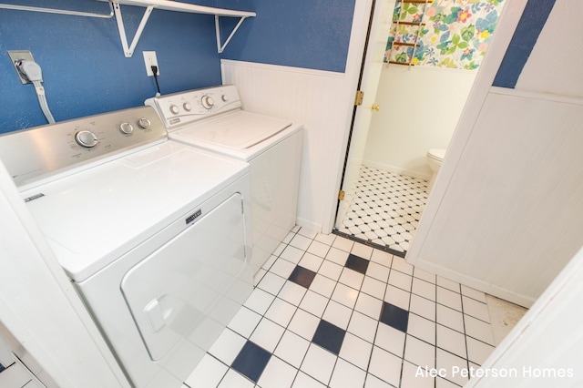 clothes washing area with light tile patterned flooring and washing machine and dryer