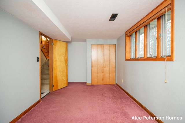 basement featuring carpet and a textured ceiling