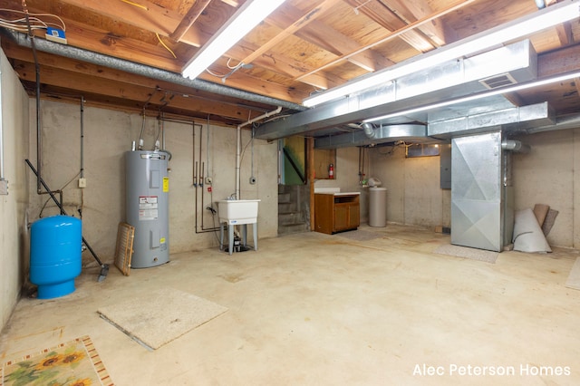 basement with electric panel, electric water heater, heating unit, and sink