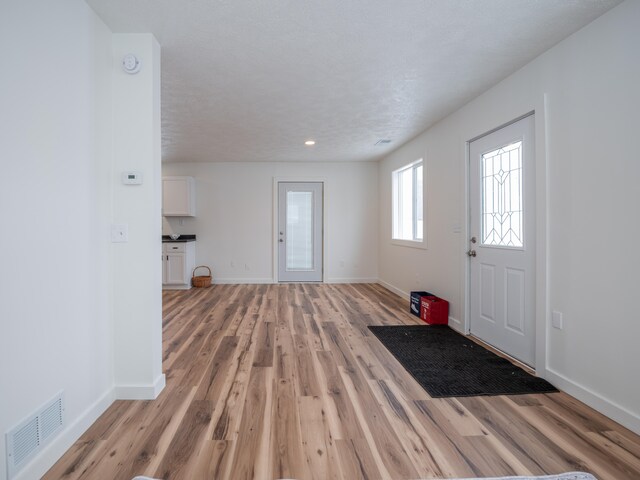 foyer featuring a textured ceiling and light hardwood / wood-style flooring