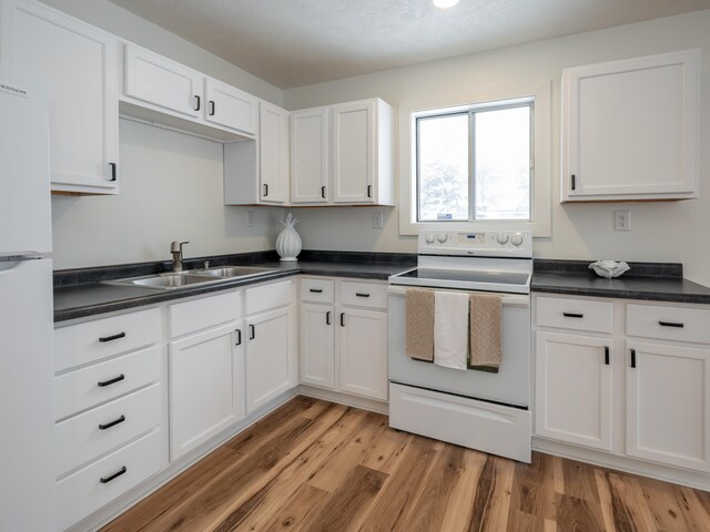 kitchen featuring light wood-type flooring, sink, white cabinets, and white appliances