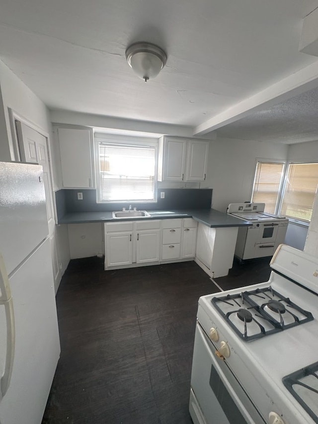 kitchen with sink, white cabinets, white appliances, and washer / dryer