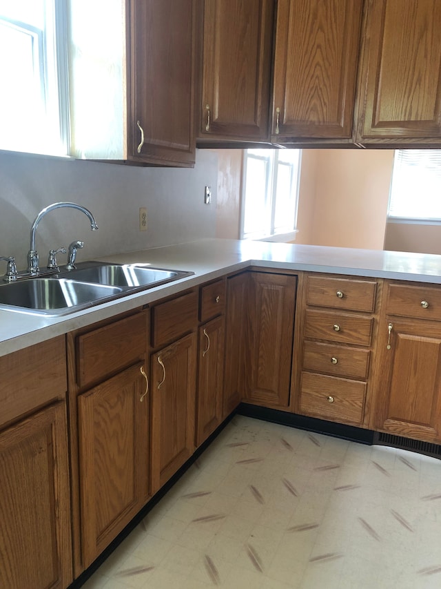 kitchen featuring kitchen peninsula, sink, and a wealth of natural light