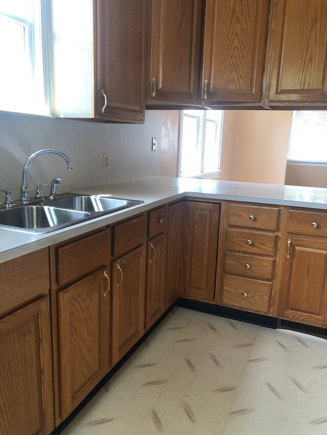 212 15th St, Port Huron, MI 48060 - kitchen with a sink, brown cabinetry, light countertops, and light floors