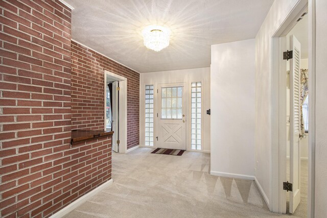 1806 Bond St, Niles, MI 49120 - foyer entrance featuring a chandelier, baseboards, brick wall, and light colored carpet