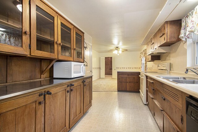 1806 Bond St, Niles, MI 49120 - kitchen featuring white appliances, brown cabinetry, light floors, a sink, and ceiling fan