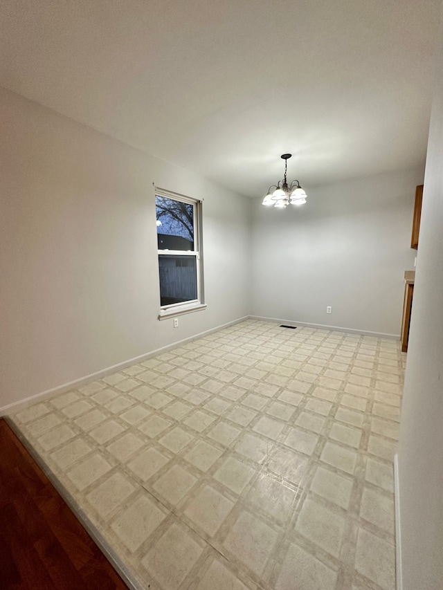 empty room featuring an inviting chandelier