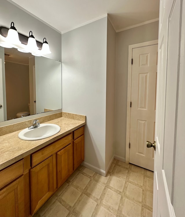 bathroom featuring vanity, toilet, and ornamental molding