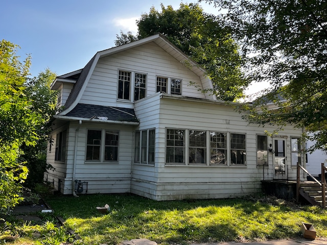 rear view of house featuring a yard