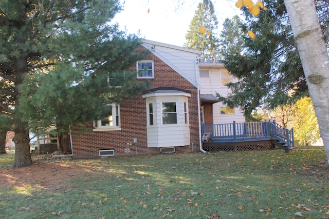 rear view of property with a lawn and a wooden deck