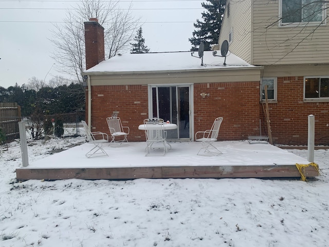 snow covered property with a deck