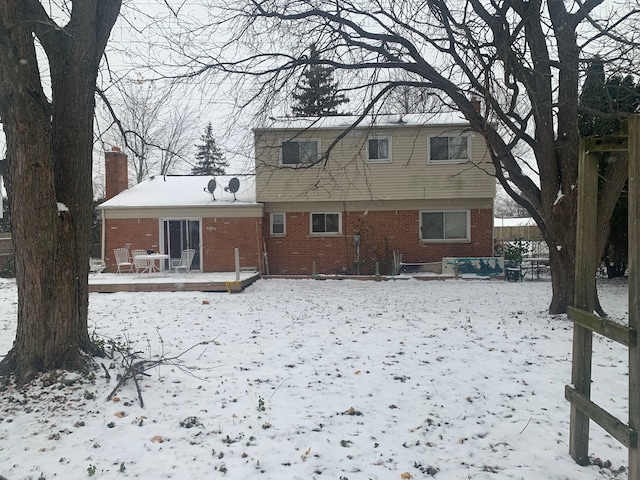 snow covered rear of property featuring a wooden deck