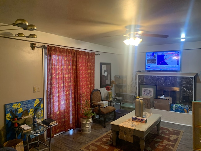 living room featuring ceiling fan and dark wood-type flooring