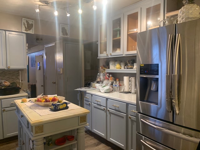 kitchen featuring backsplash, dark hardwood / wood-style flooring, stainless steel fridge, and a center island