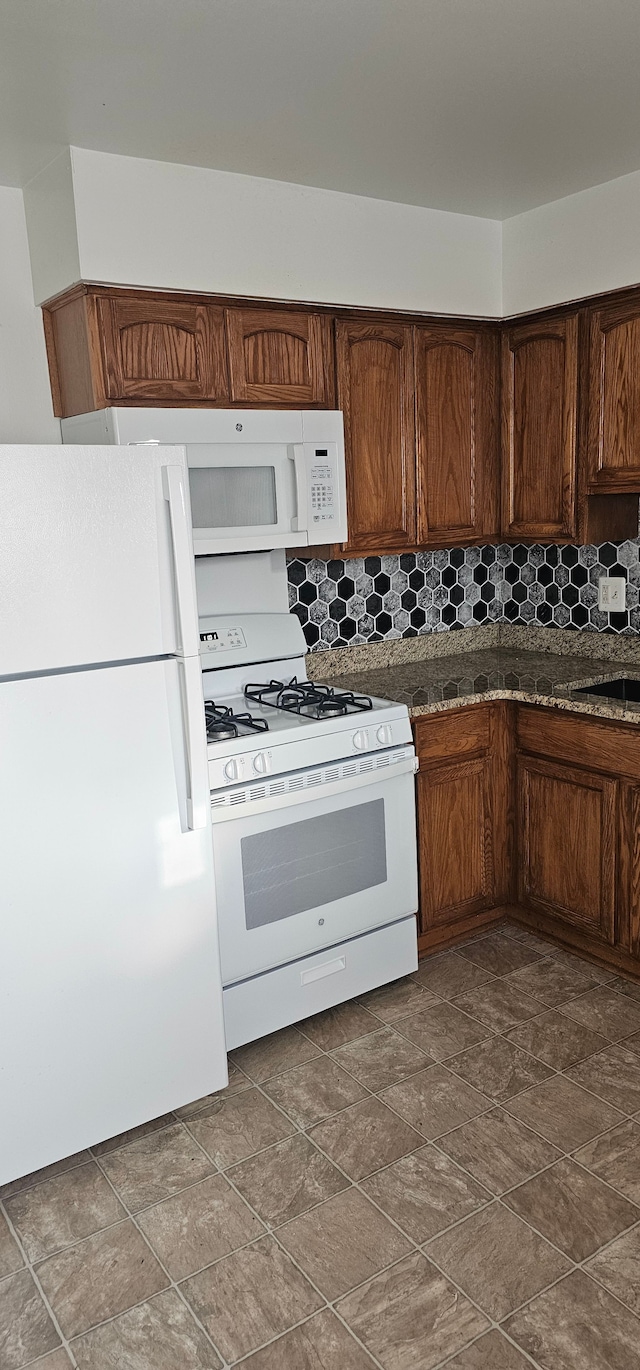 kitchen featuring decorative backsplash and white appliances