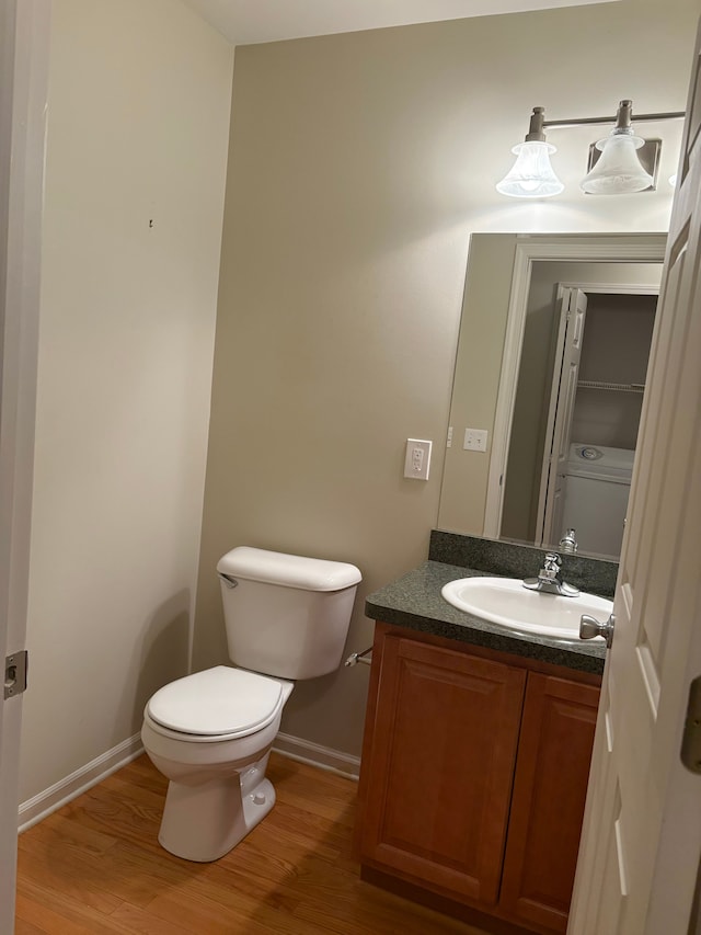 bathroom with hardwood / wood-style floors, vanity, and toilet