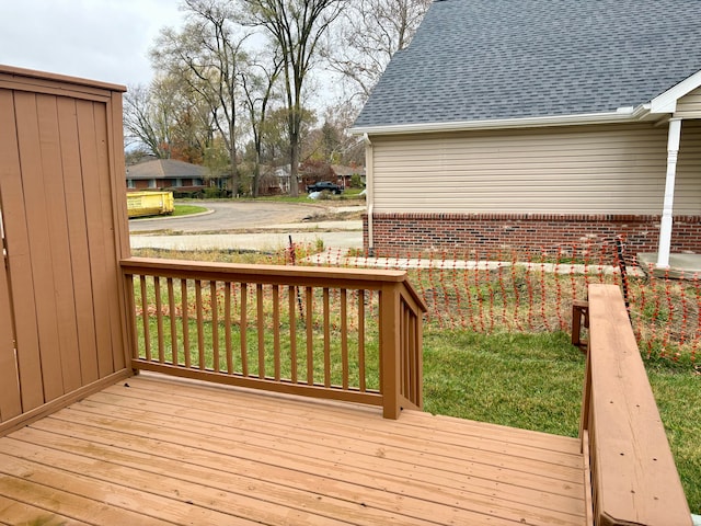 wooden terrace featuring a lawn