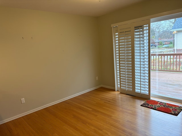 empty room with plenty of natural light and light hardwood / wood-style flooring