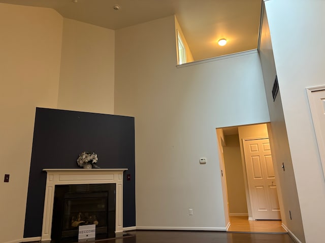 living room with a towering ceiling and hardwood / wood-style flooring